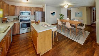 Open and contemporary layout with dining room flowing into the kitchen. There are stainless steel appliances as well as an island.